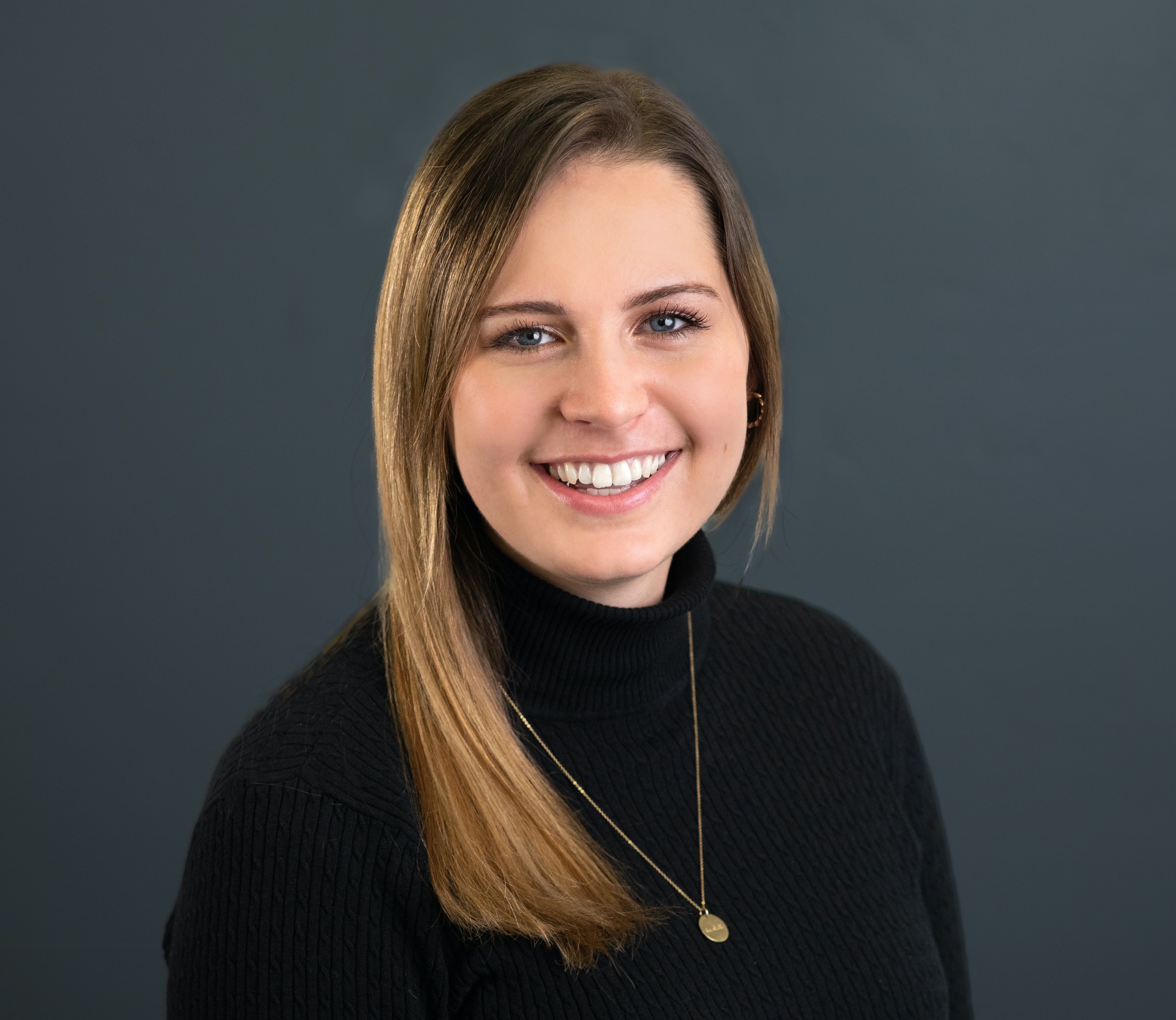 Rachel Weiss smiling in a casual professional outfit